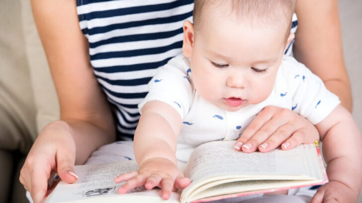mom reading board book to one-year-old baby