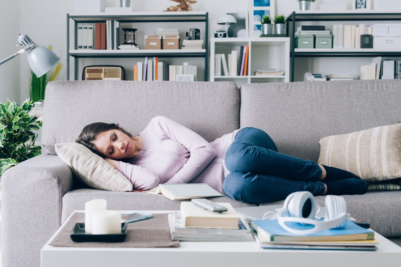 pregnant woman in her first trimester sleeping on the couch, not doing anything