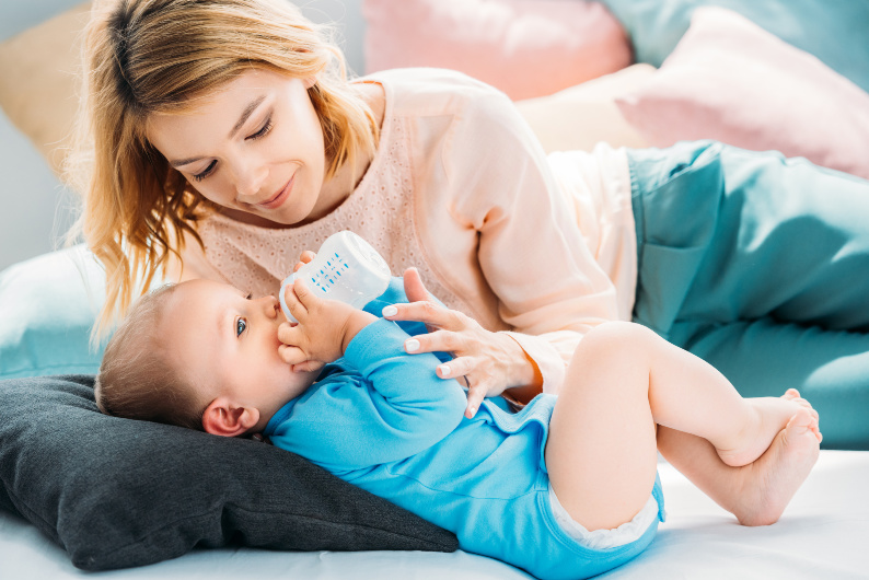 mom feeding her baby formula but secretly feeling guilty about it
