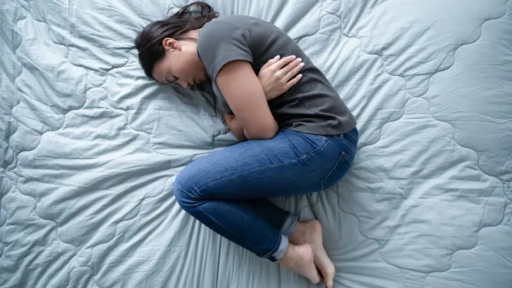 sad woman laying on her bed after missed miscarriage