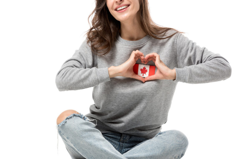 woman holding mini canadian flag over her heart