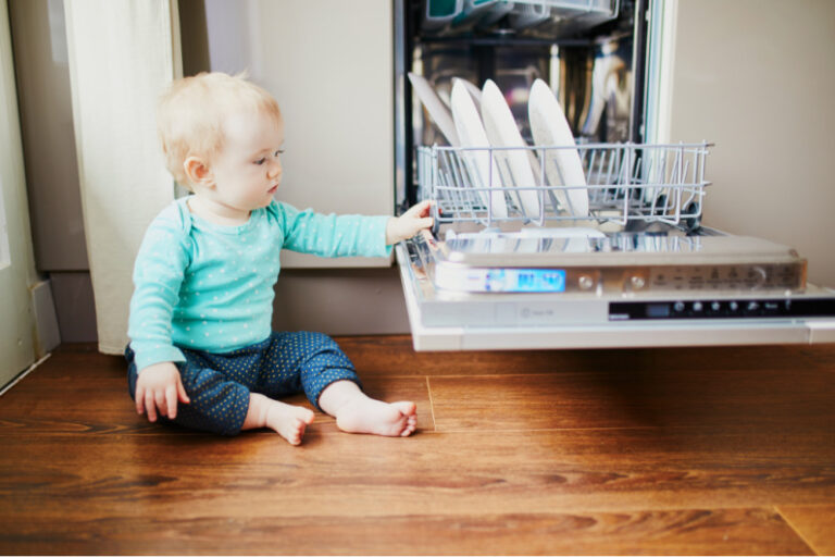 baby touching dishes in dishwasher