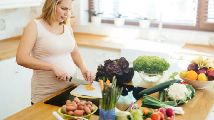 pregnant woman chopping vegetables, preparing Trim Healthy Mama meal