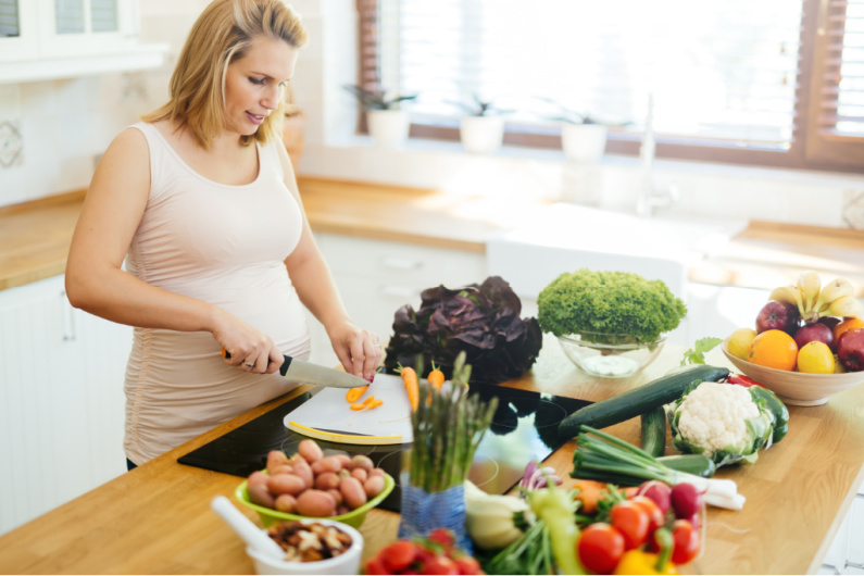 pregnant woman chopping vegetables, preparing Trim Healthy Mama meal