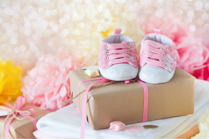 baby shower gift with pink baby shoes on top.