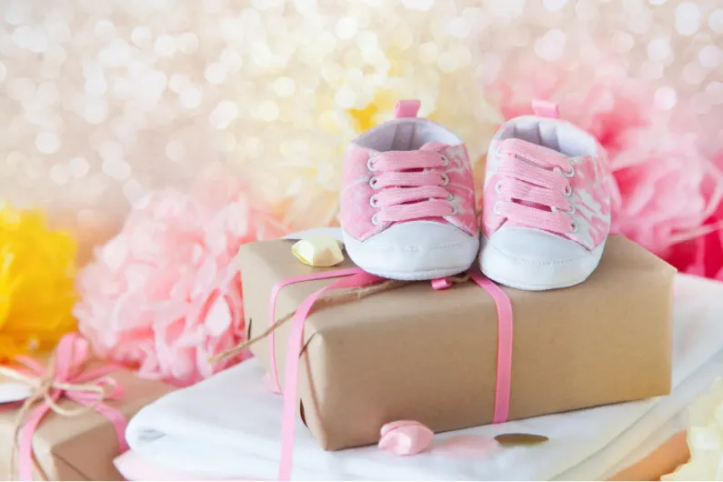 baby shower gift with pink baby shoes on top.