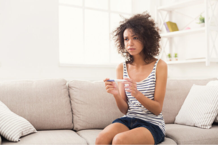 disappointed woman TTC holding negative pregnancy test