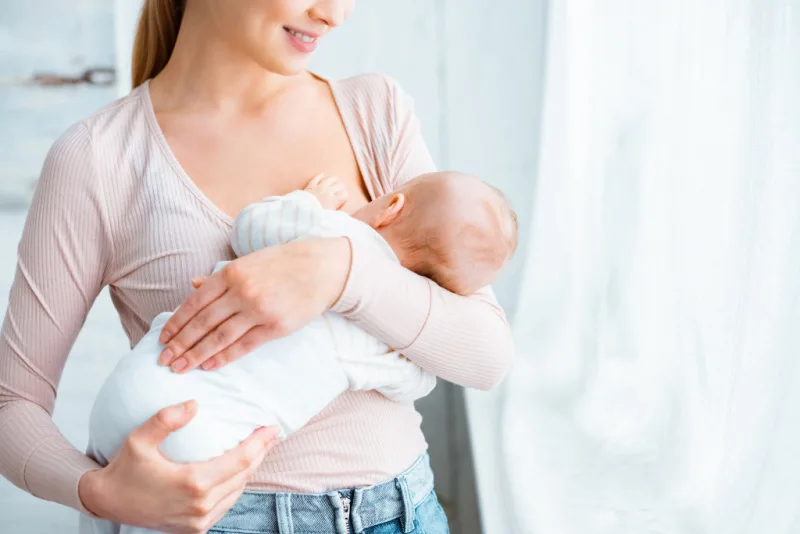young mom nursing baby while standing up