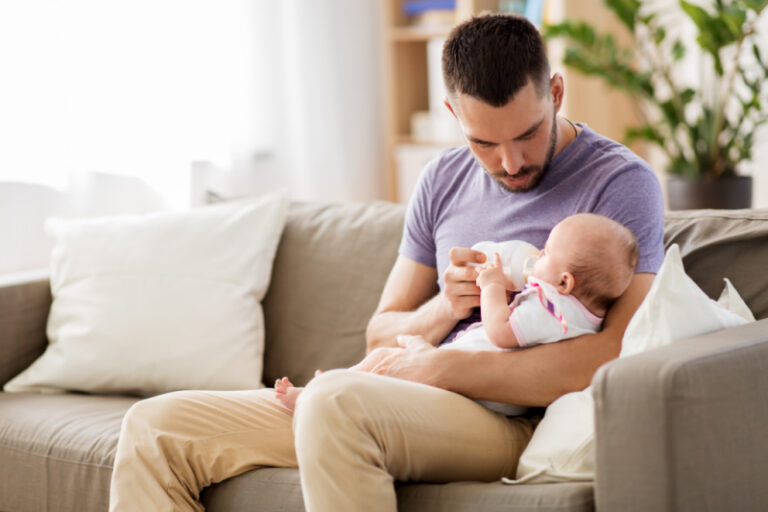 dad trying to feed a baby who is refusing a bottle