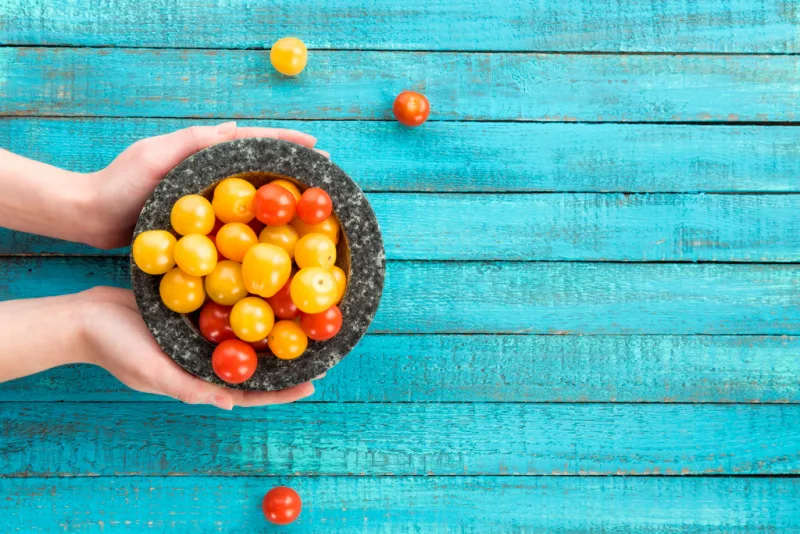 breastfeeding mom holding cherry tomatoes in bowl