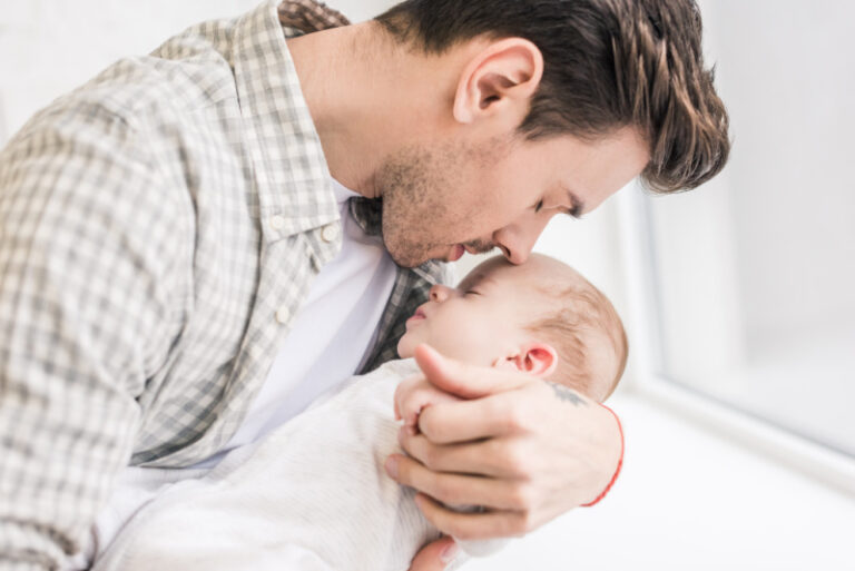 new dad holding baby at hospital