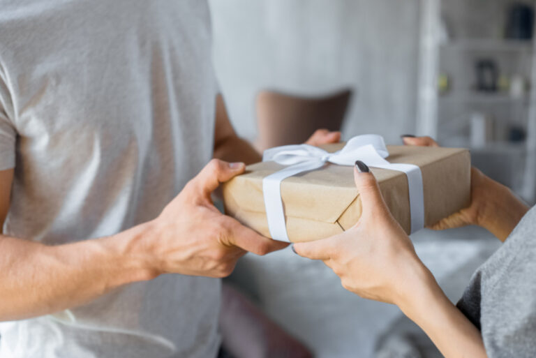 pregnant woman giving Father's Day gift to expecting dad