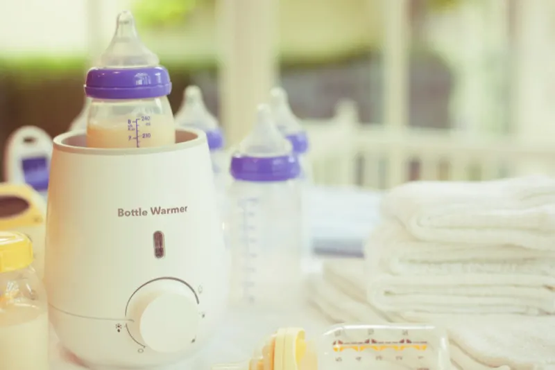 bottle warmer and bottles on a counter