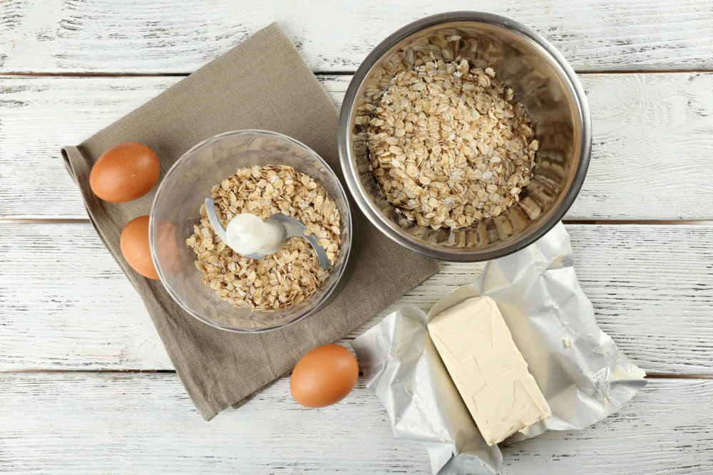 a few ingredients for oatmeal chocolate chip cookies with fenugreek on white wooden tabletop