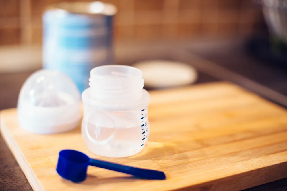 bottle with water and formula container open on counter