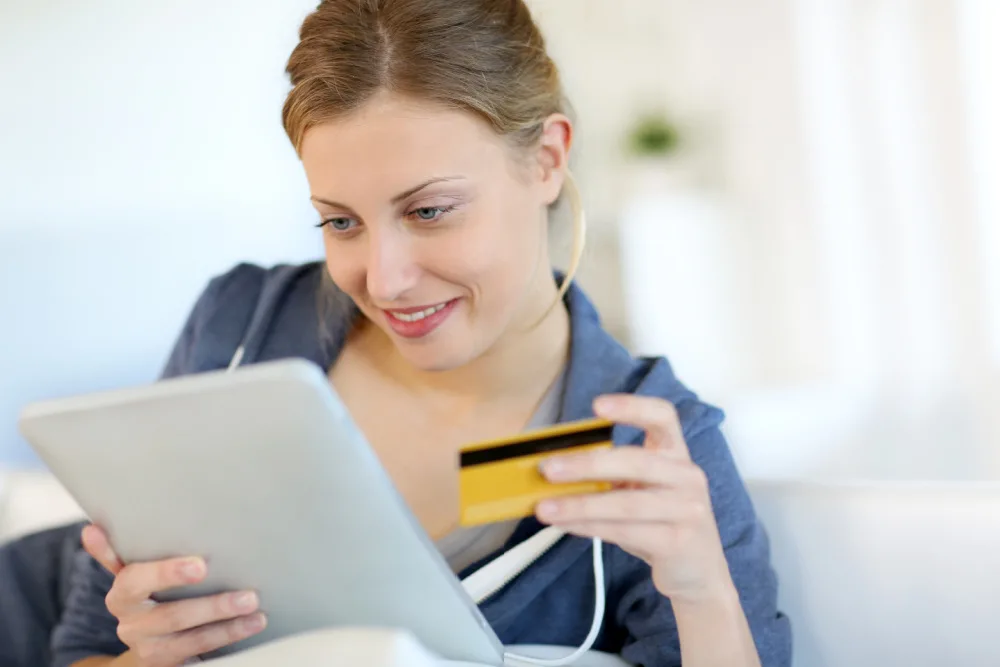 woman shopping online for inexpensive baby shower gifts, tablet and credit card in hand