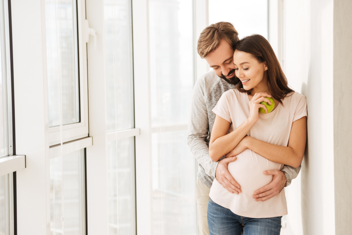 husband hugging pregnant wife, supporting her during pregnancy