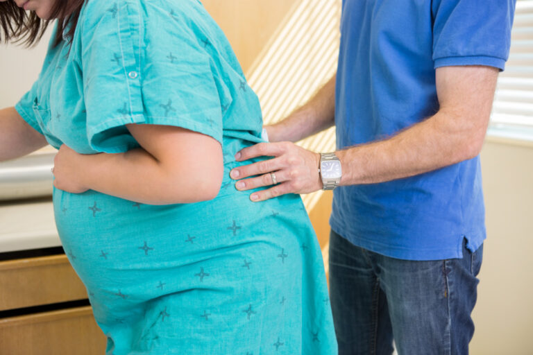 dad helping mom during natural labor, giving back massage