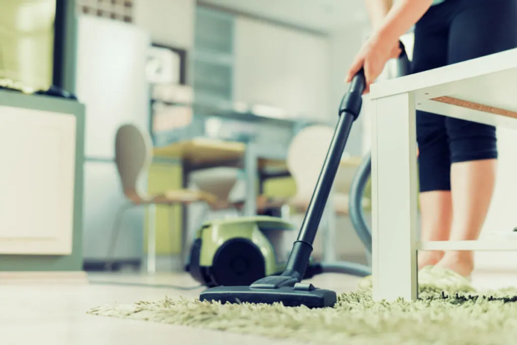 mom vacuuming and cleaning house while baby is sleeping