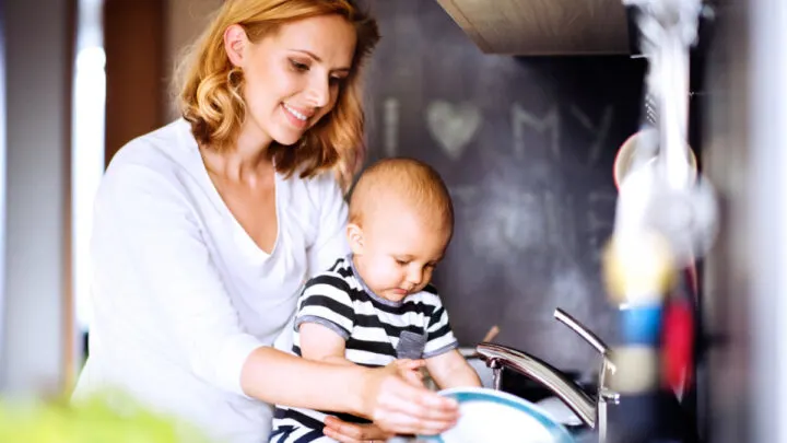 mom doing housework while holding baby