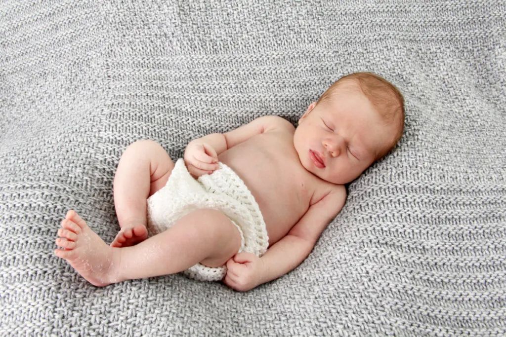 newborn baby boy with biblical name, sleeping on gray baby blanket