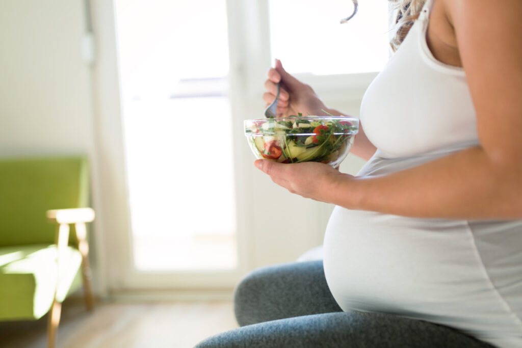 Pregnant woman eating healthy salad