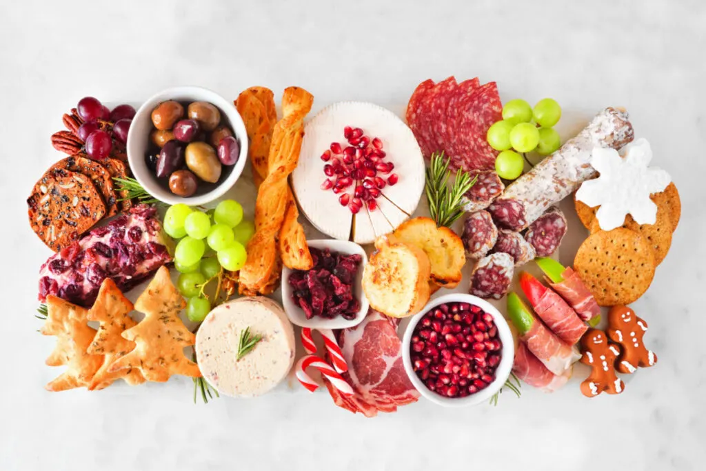 baby shower charcuterie board. Top view against a white wood background. Variety of cheeses and deli meats