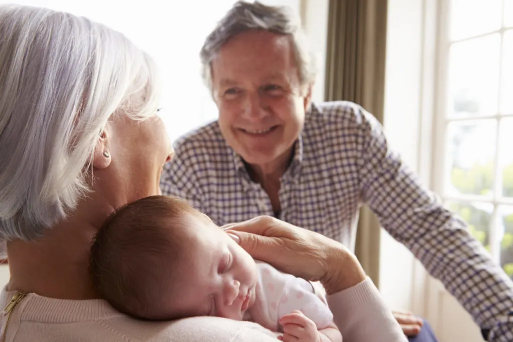 grandparents enjoying snuggling newborn 