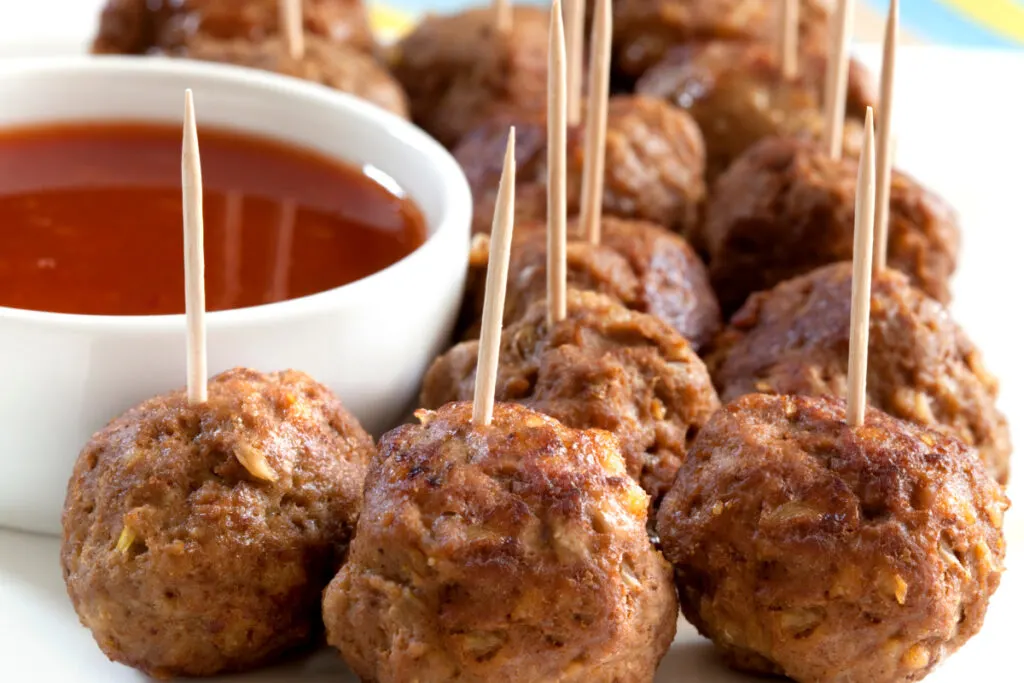 meatballs with toothpicks and sweet and sour dipping sauce