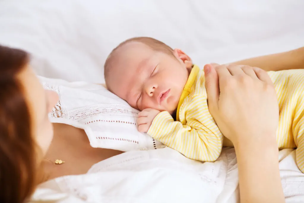 newborn sleeping child sleeping peacefully on mothers chest