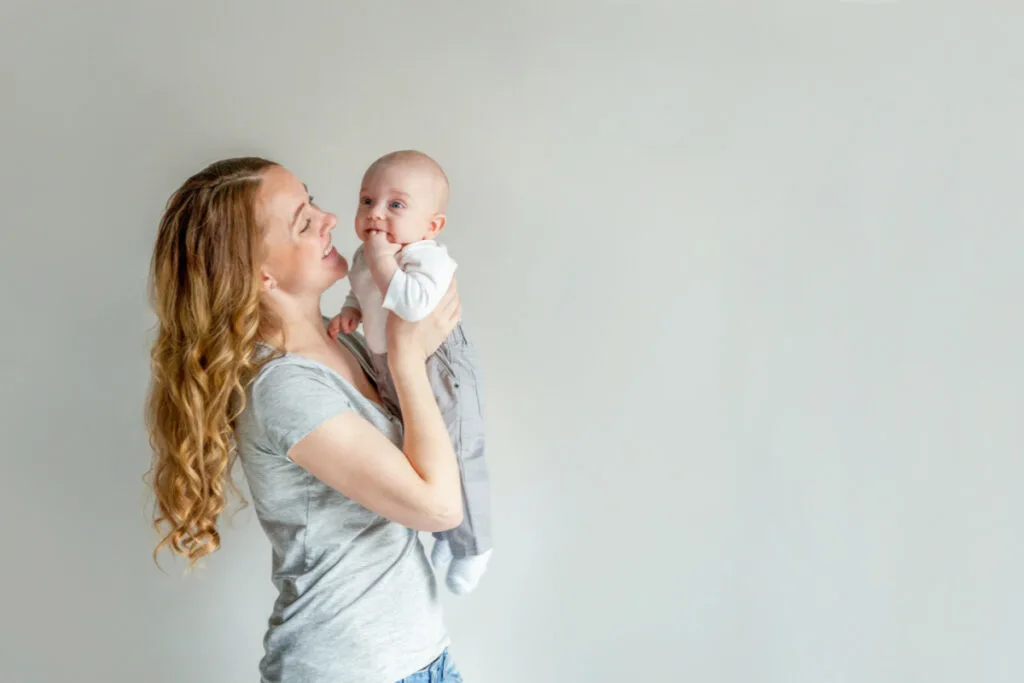 new mom holding baby and smiling