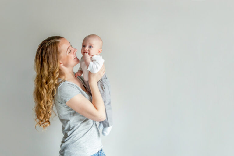new mom holding baby and smiling