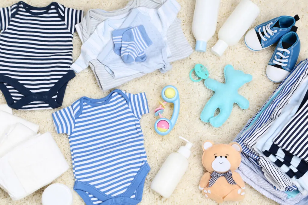 baby boy clothes spread out and folded on floor