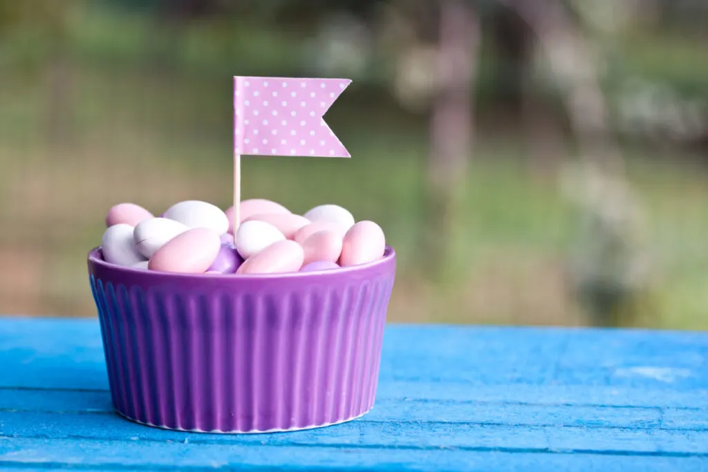 ramekin filled with candy for baby shower favors, with pink baby girl flag