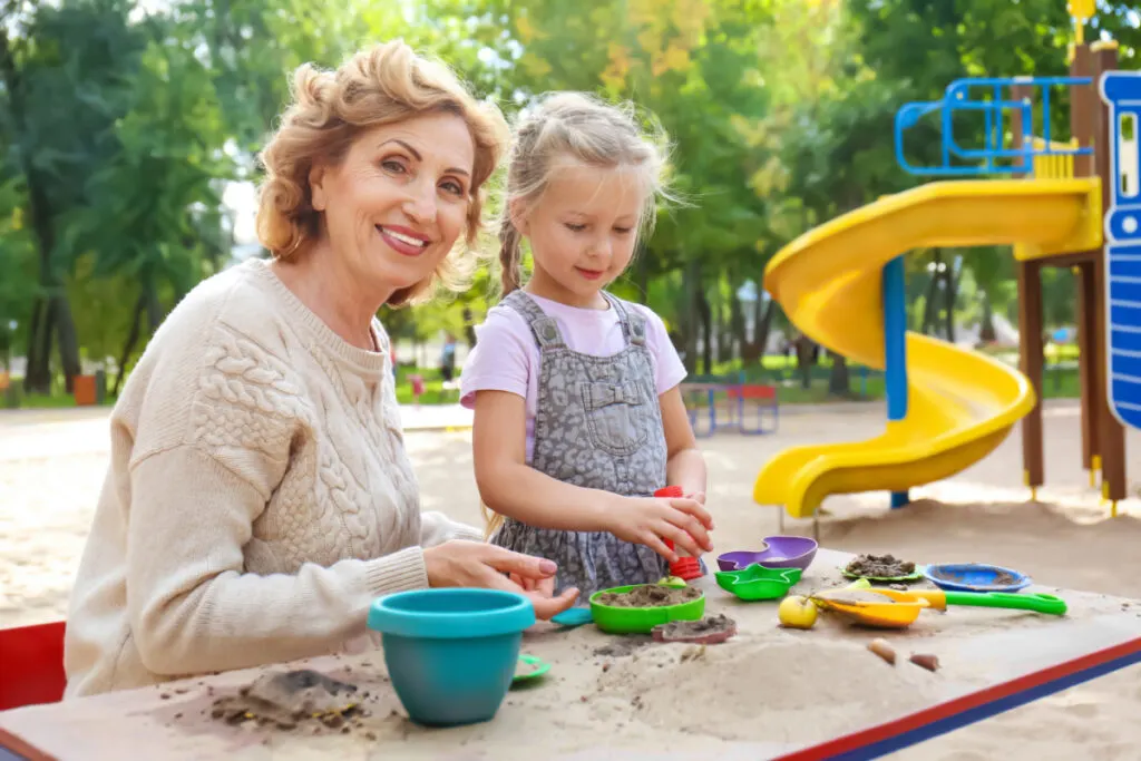 Cute little girl with grandmother in park on sunny day