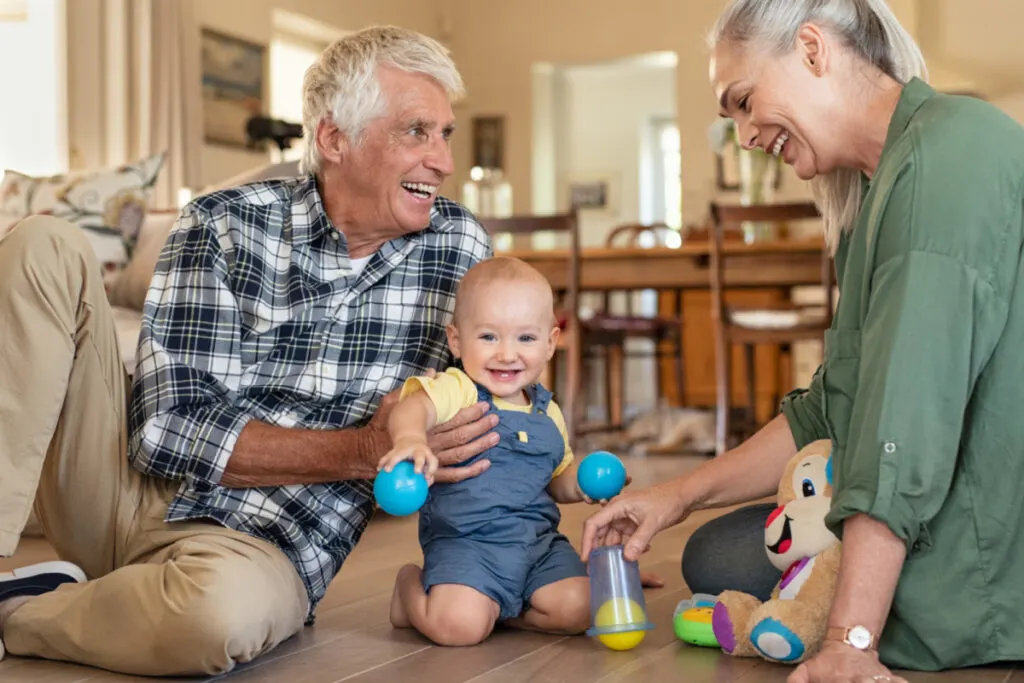 smiling grandparents playing with ball gift they brought their grandchild