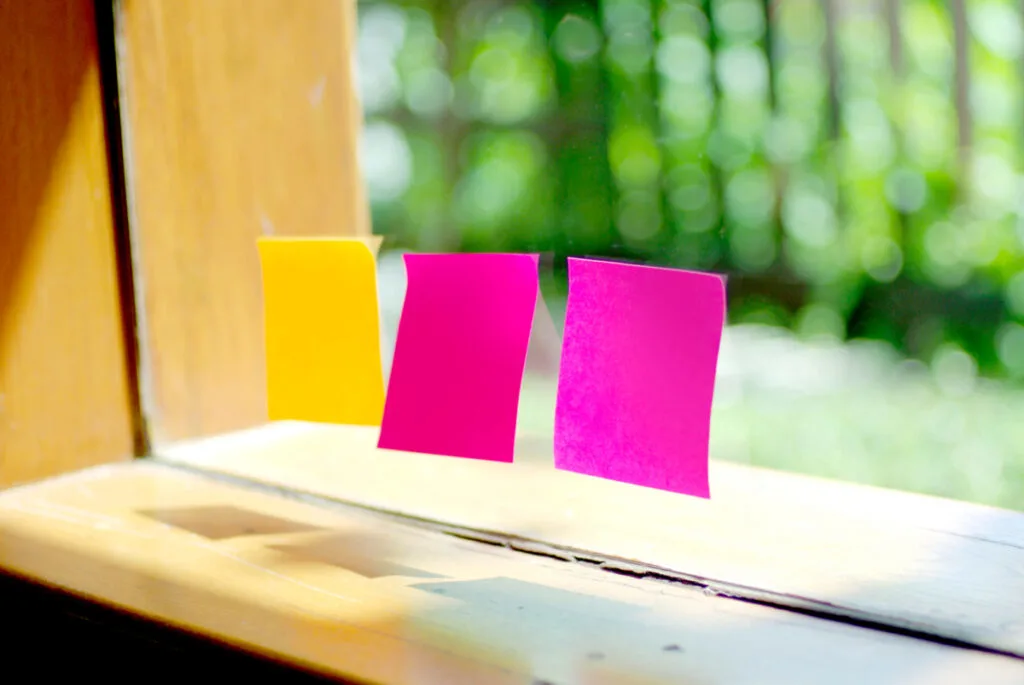 three colorful post it notes on window