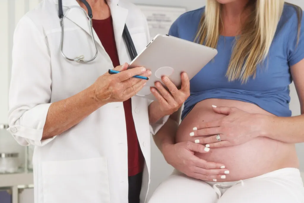pregnant woman discussing birth plans with OB/GYN, wondering how to factor in previous urinary retention