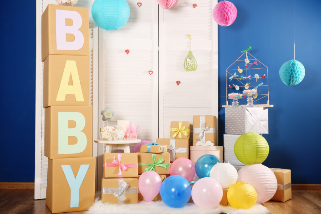 pile of baby shower gifts of various sizes and big box tower spelling "BABY"