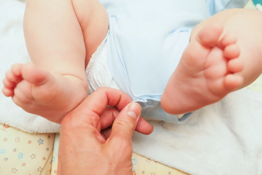 dad changing diaper to add doublers before bed to prevent leaking