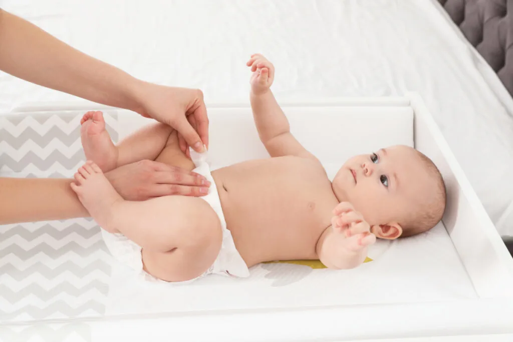 mother changing diaper, checking for leg gaps to prevent leaks