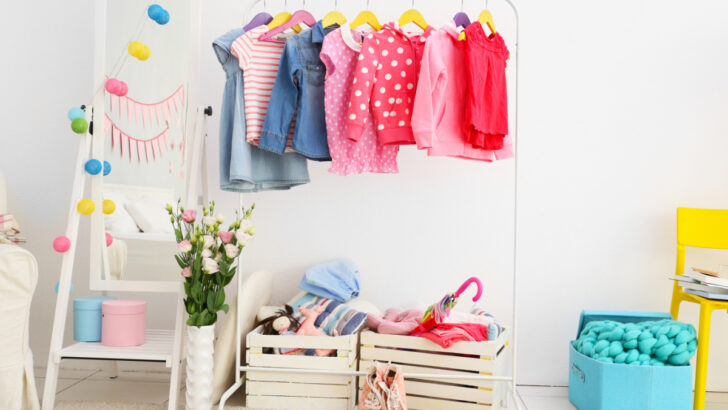 rolling wardrobe rack with colorful baby clothes on it