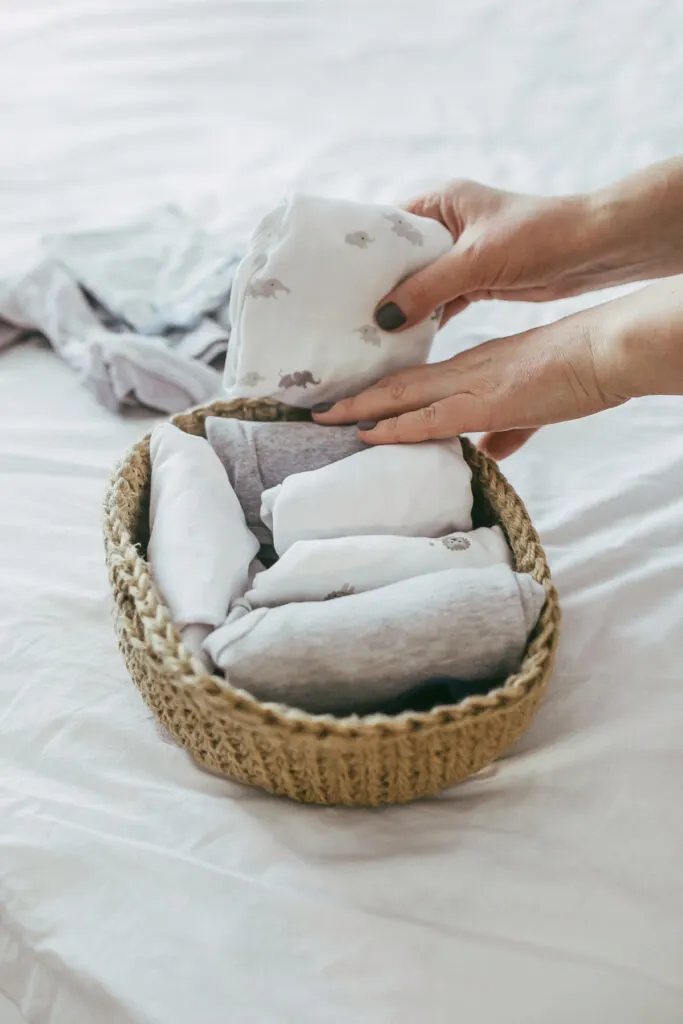 organized baby clothes file folded into basket