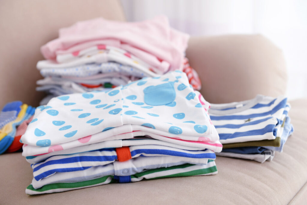 outgrown baby clothes washed and folded neatly, waiting to be stored