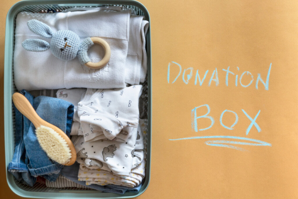 gently used unwanted baby items in box, ready to be donated, "donation box" written next to it