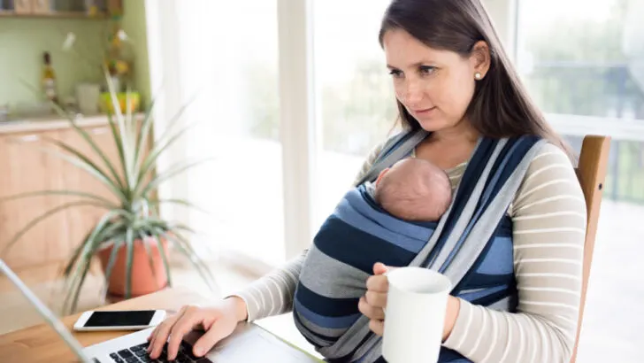 mom wearing her baby getting things done on computer