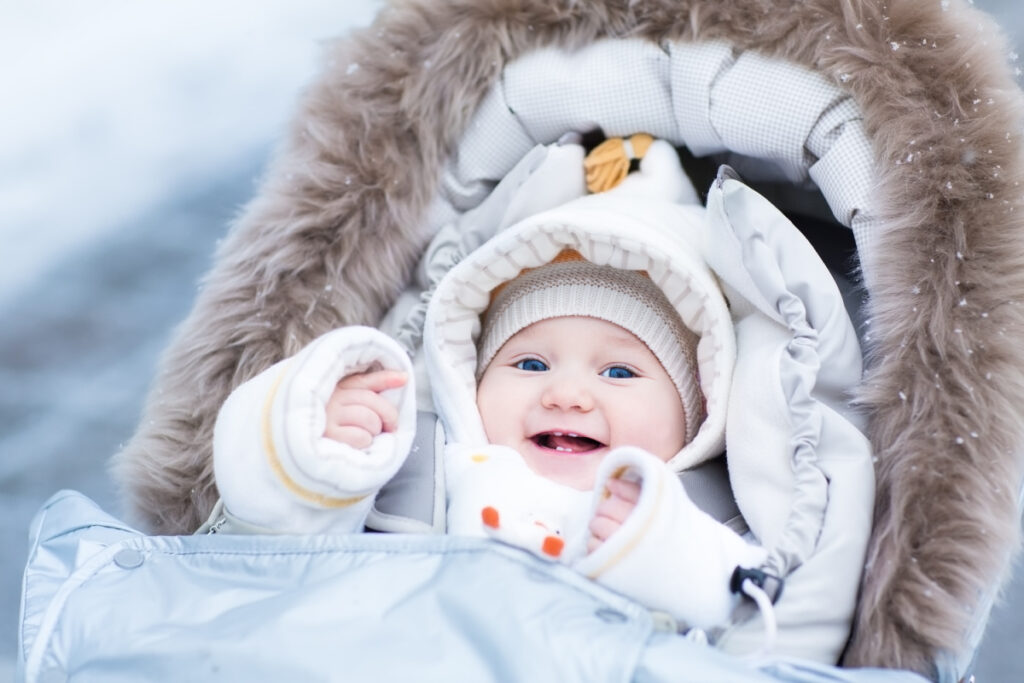 baby bundled up in winter clothing essentials while traveling to a cold climate.