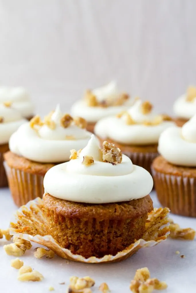 cream cheese cupcake unwrapped with walnut topping.