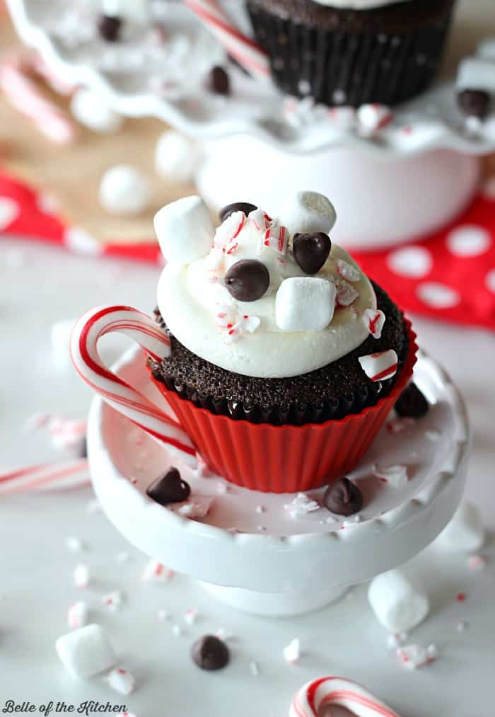hot chocolate cupcakes with marshmallow buttercream frosting, with candy cane, chocolate chip and mini marshmallow toppings.