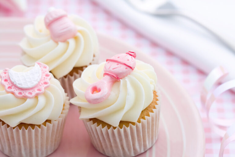 frosted cupcakes with rattle on top for baby shower.